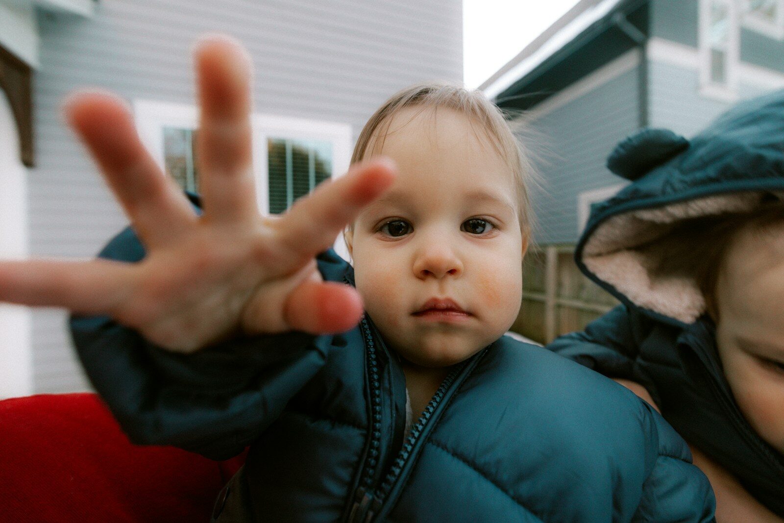 A baby reaches out with a hand.